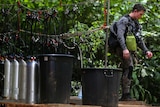 A diver stands next to scuba equipment used during the rescue attempt at the Thai cave