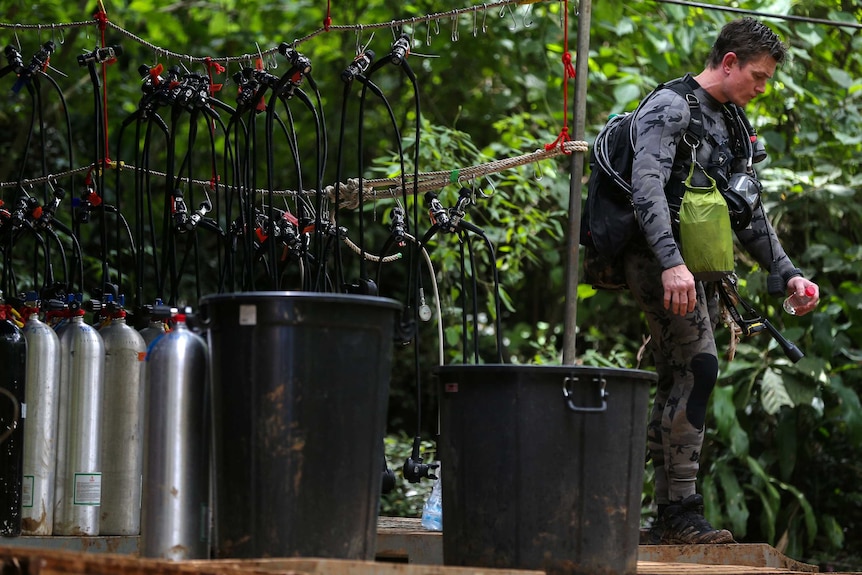 A diver stands next to scuba equipment used during the rescue attempt at the Thai cave