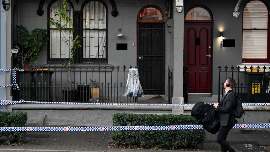 A man walks past a house.