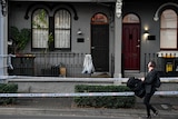 A man walks past a house.