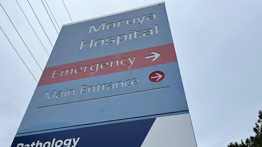 A blue hospital sign for Moruya Hospital, with directions to emergency and the main entrance.