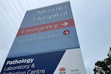 A blue hospital sign for Moruya Hospital, with directions to emergency and the main entrance.