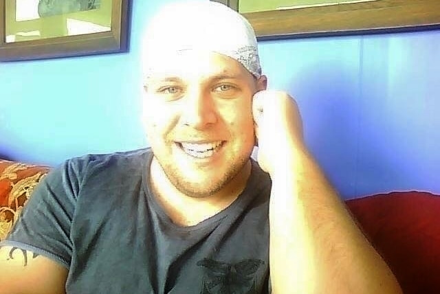 A head and shoulder shot of Jed Beaumont sitting down on a couch wearing a bandana.