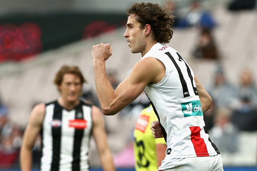 A St Kilda AFL player pumps his left fist after kicking a goal against Collingwood.