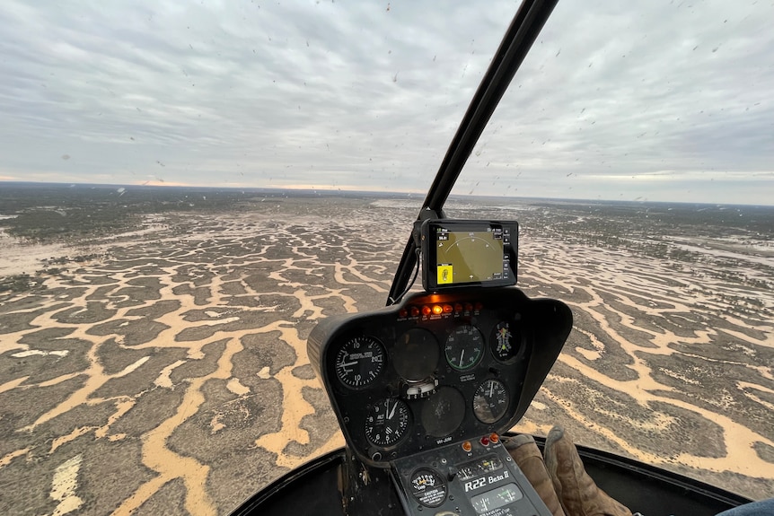 Channels full of water across a large paddock as seen from a helicopter.