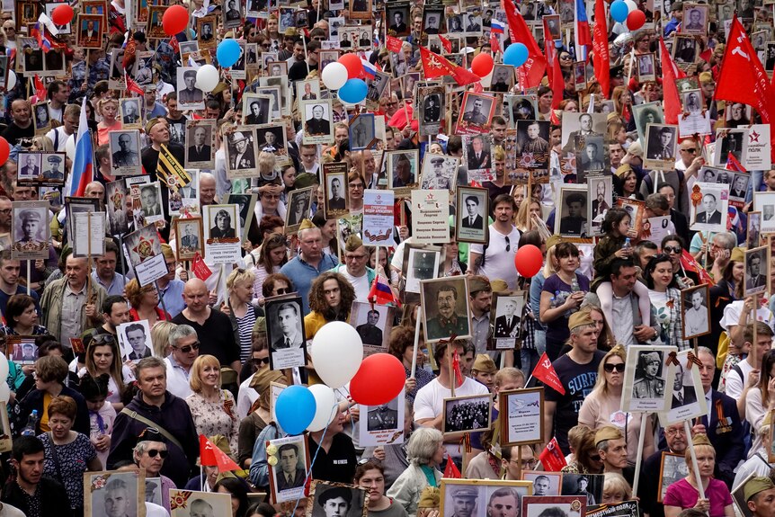 Russians carry portraits of people in Victory Day parade
