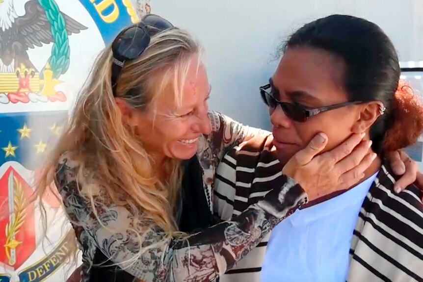 Jennifer Appel smiles at Tasha Fuiava on board a Navy boat.