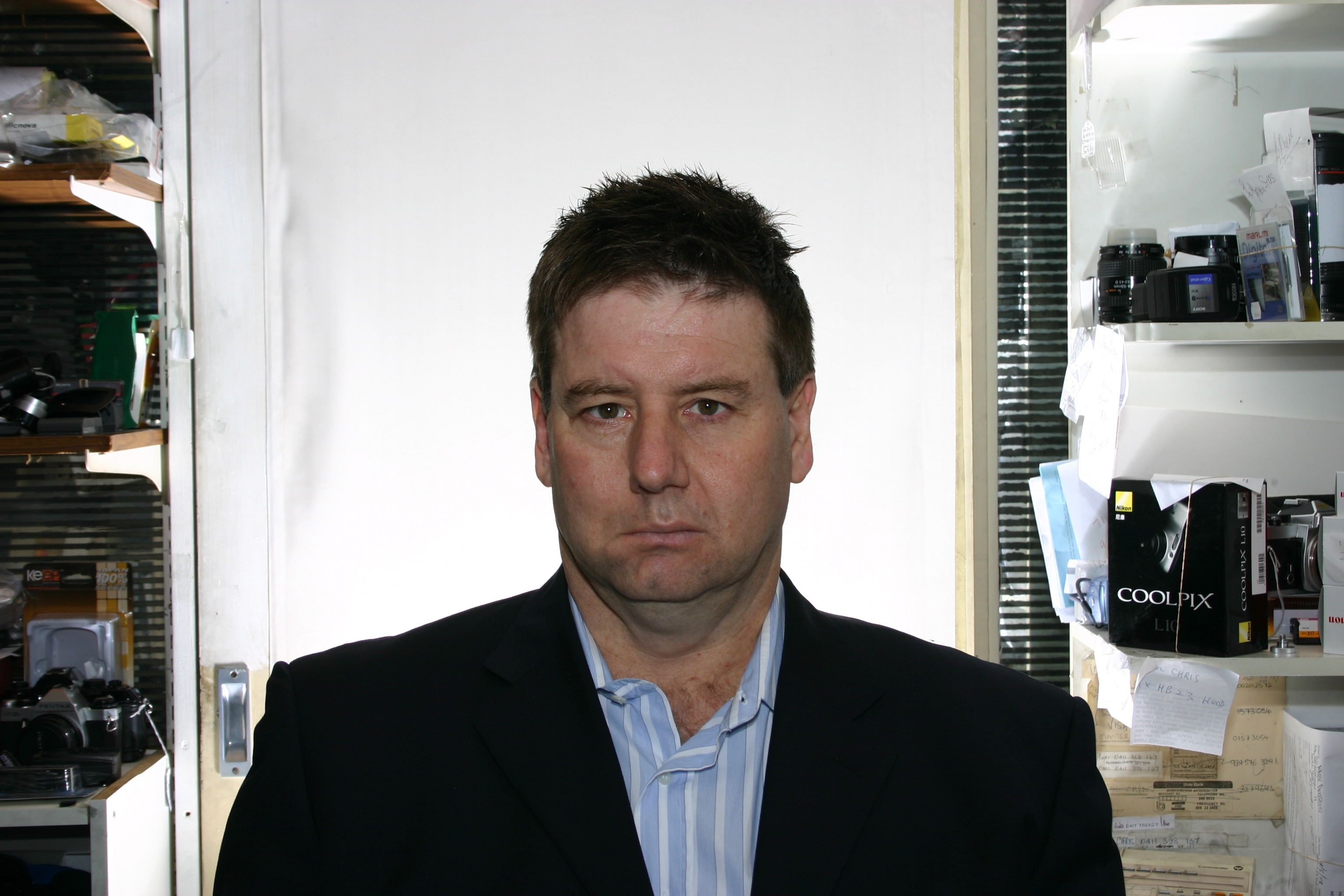 A middle-aged man looks into the camera with a serious expression.