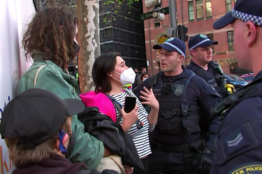 A woman wearing a mask speaks to police