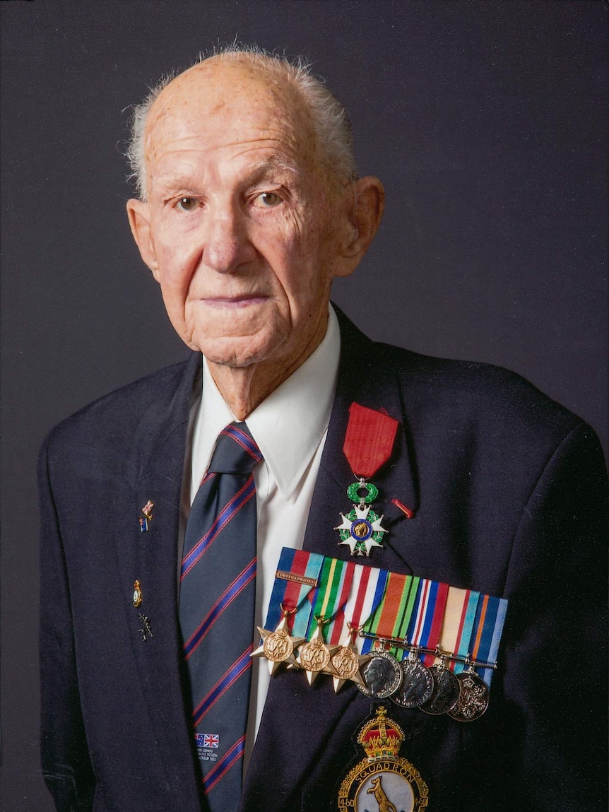 Portrait of an elderly man in a suit and tie wearing military medals.