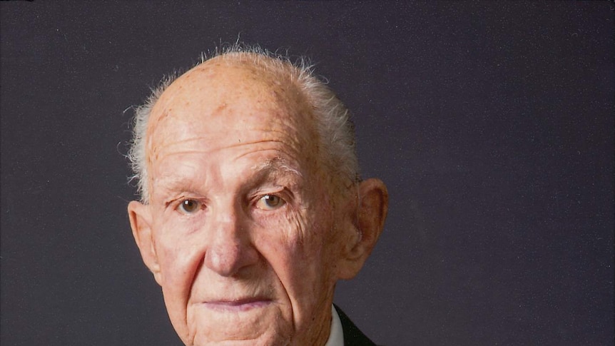 Portrait of an elderly man in a suit and tie wearing military medals.