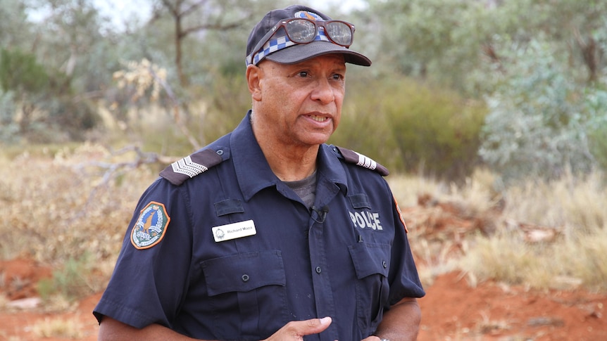 A man in a blue police shirt and hat 