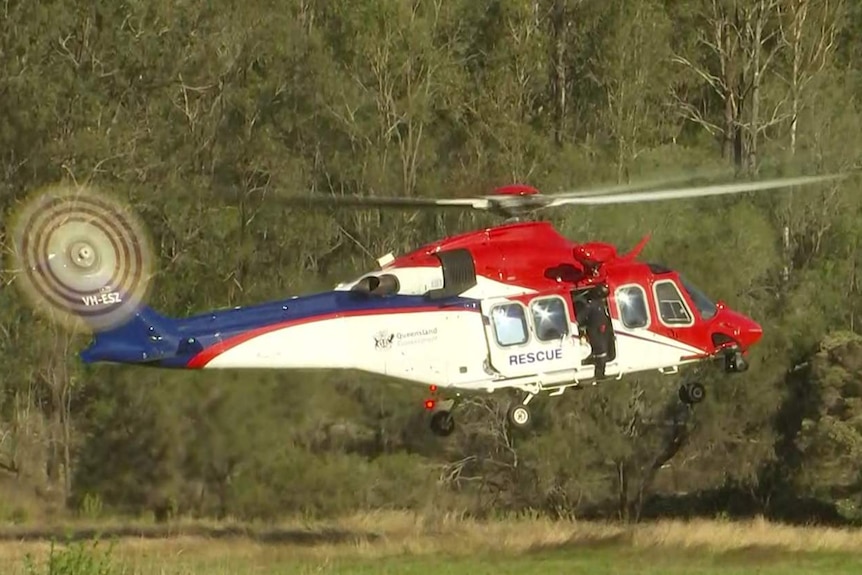 A rescue helicopter takes off from a paddock at a property at Greenbank.
