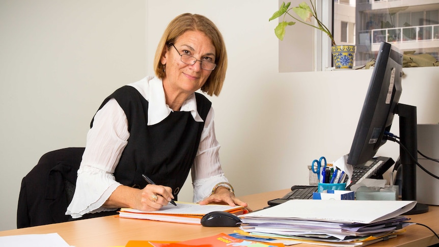 Bronwyn Ambrogetti sits at her desk.