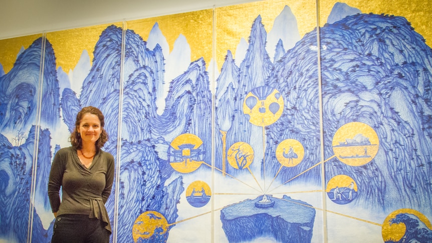 Curator Dr Sophie McIntyre with the artwork Journey to Australia drawn entirely with biro.