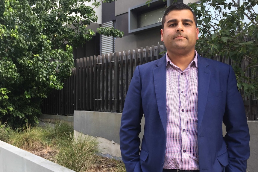 Roscon general manager Sahil Bhasin stands in front of an apartment building with his hands in his pockets.