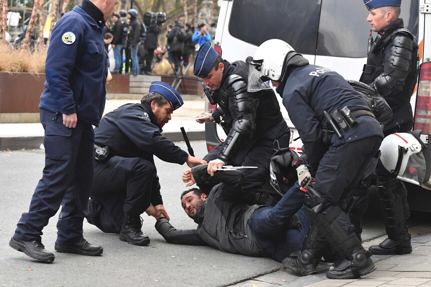 Police hold down a protester as they try to detain him