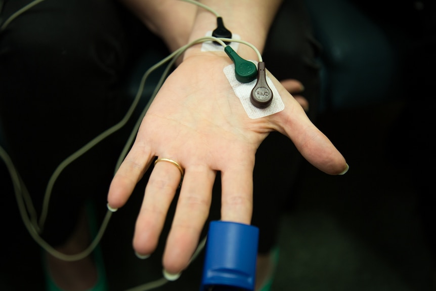 A pulse oximeter is attached to the participant's hand to measure heart rate, blood oxygen percentage and skin sweat levels.