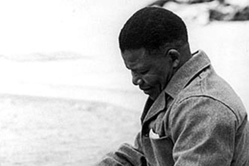 Nelson Mandela sews prison clothes in the yard of Robben Island prison, 1966