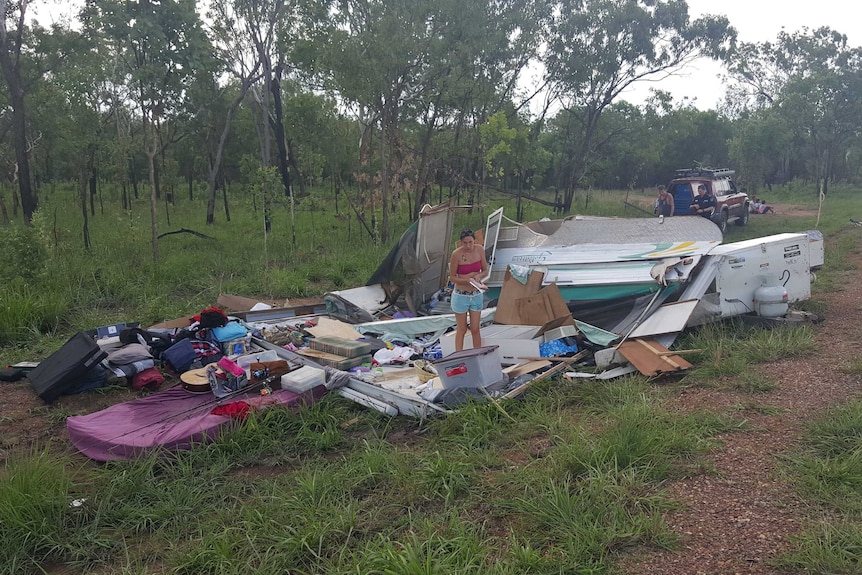 A woman stand in the wreckage of a caravan after crash.