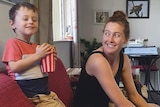 woman smiles at her son sitting on the couch
