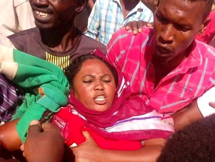 Demonstrators help a women who was shot in her hand during clashes with security forces