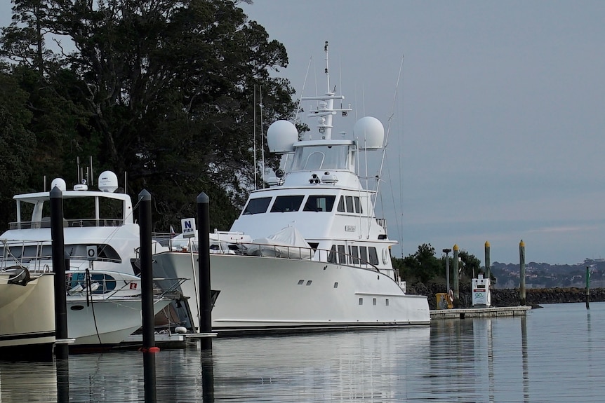 A white luxury sports yacht on water at dusk.