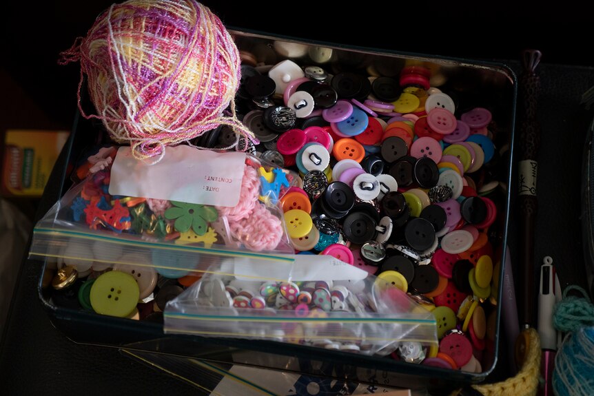 Interior scene showing tins of buttons and balls of wool