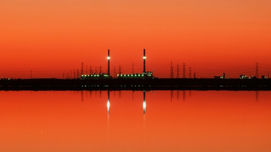 Power station reflected in water.