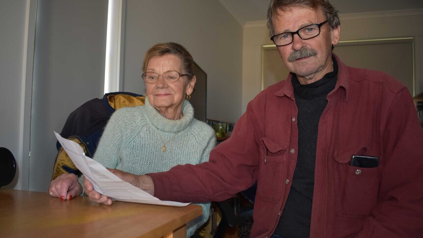 Two people, one male, one female looking at their rent bill inside a unit in Morwell.