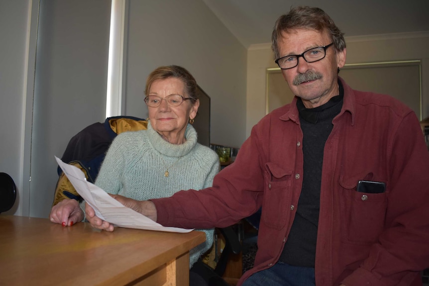 Two people, one male, one female looking at their rent bill inside a unit in Morwell.