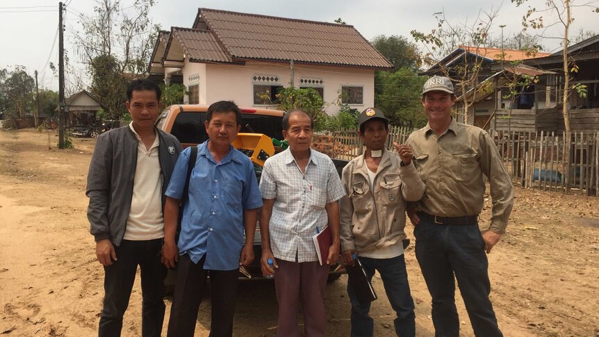 Leigh Vial (far right) stands with Laos farmers after a demonstration of the rice seeder.