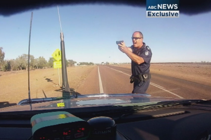 Senior Constable Stephen Flanagan with a gun pointed at a motorist