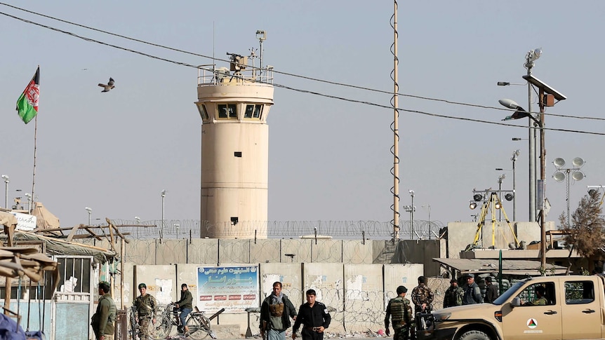 Afghan National Army soldiers stand outside the Bagram Airfield NATO air base entrance gate.