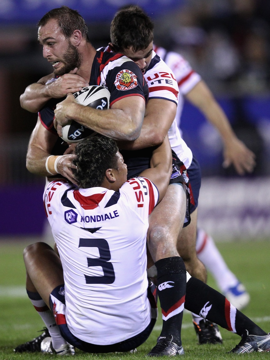 Warriors captain Simon Mannering carries the Roosters through the line.