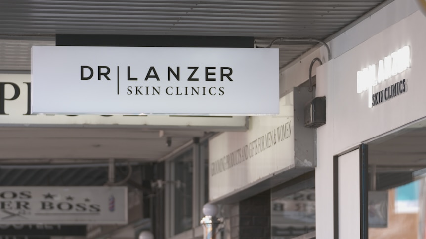 A sign outside a storefront that says "Dermatological clinics Dr Lanzer".