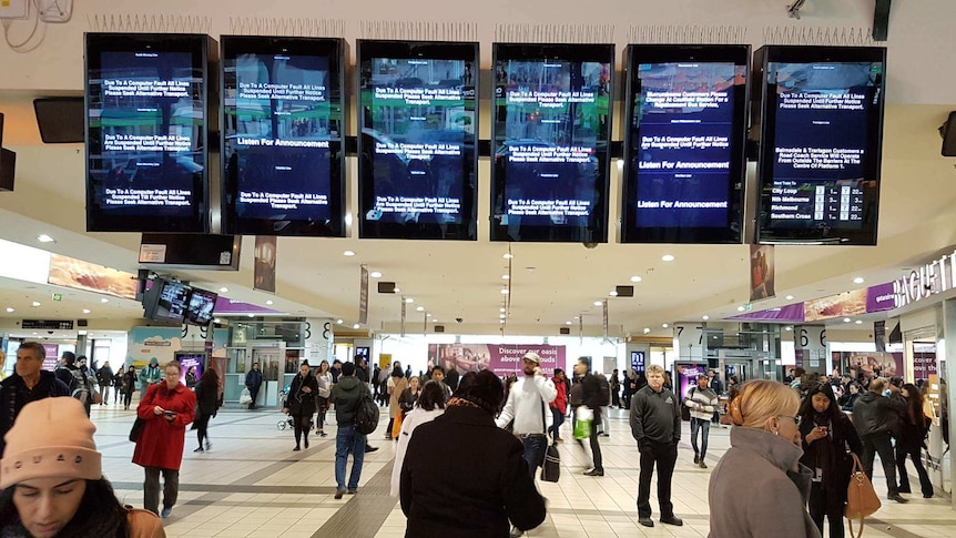 Screens at Flinders Street station show all trains lines suspended after a computer fault