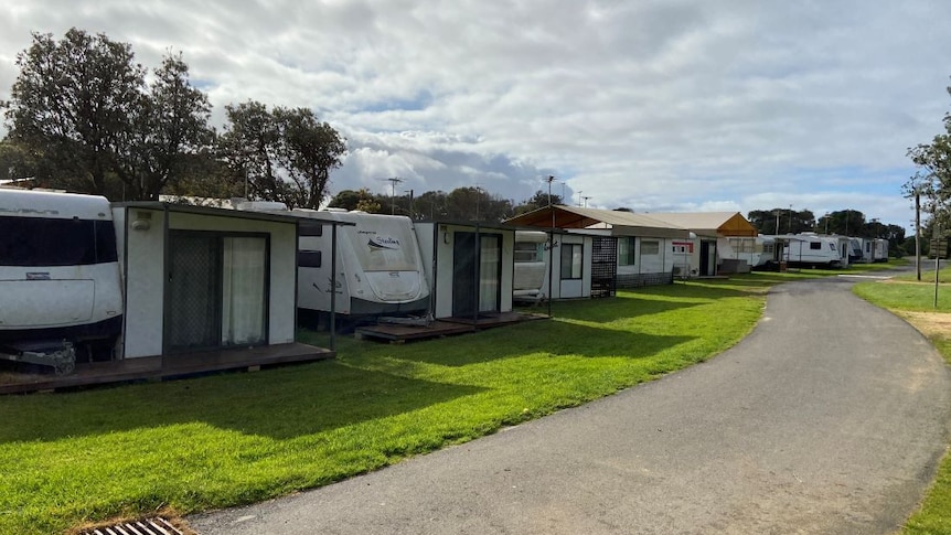 A row of empty caravans with annexes in a caravan park.