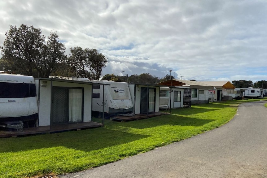 A row of empty caravans with annexes in a caravan park.
