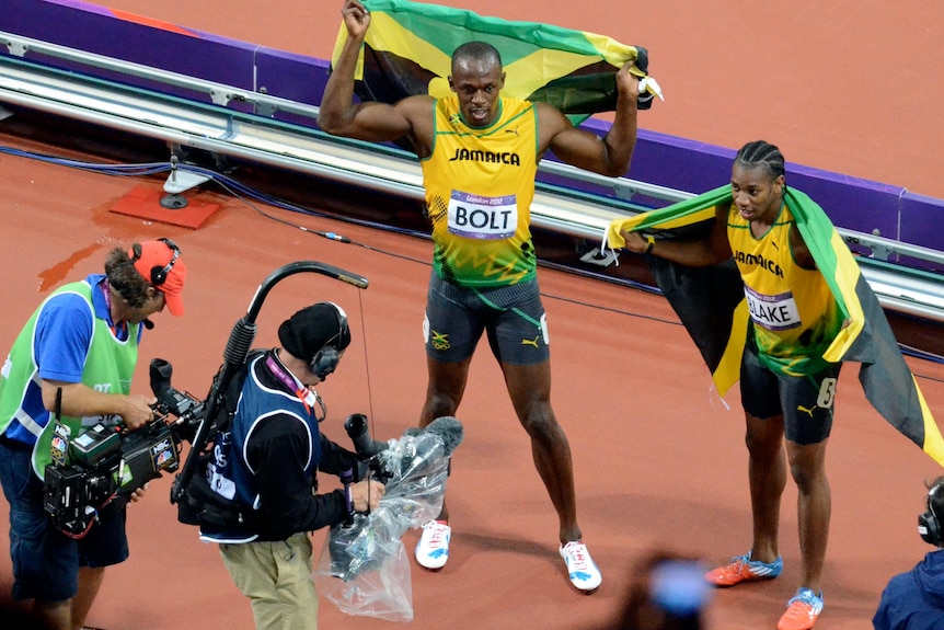 Jamaica's Usain Bolt and Yohan Blake are followed by media after the 100m final.