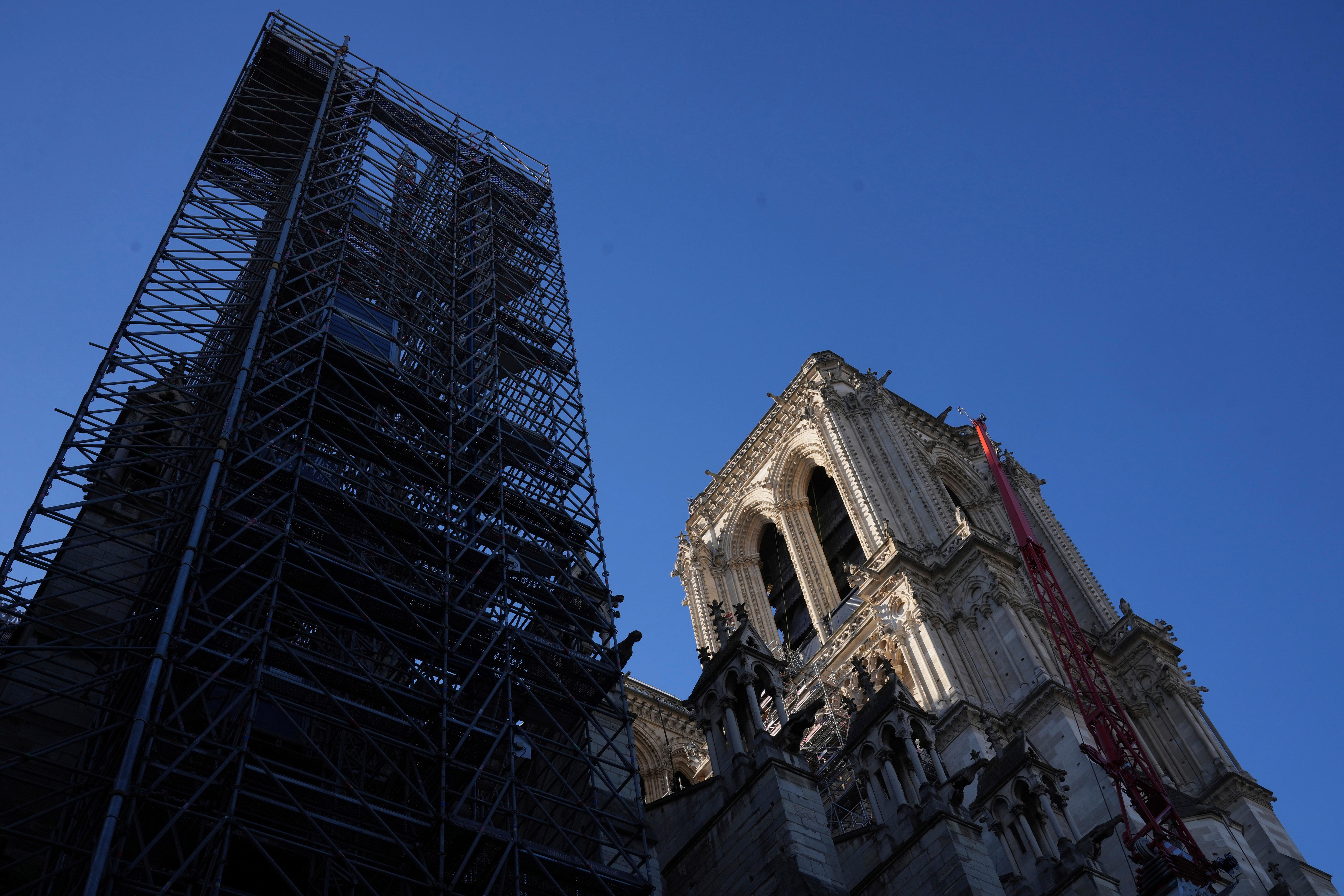 A tower of scaffolding rises into the sky next to a cathedral tower