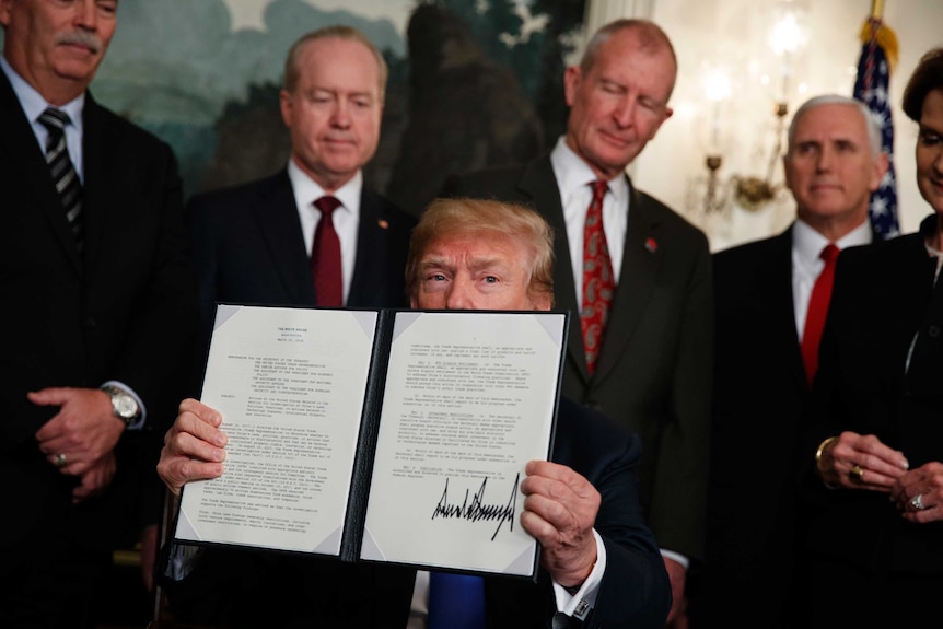 Donald Trump displays signs a memorandum imposing tariffs on China