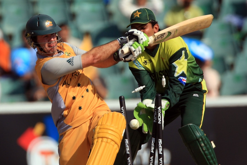 Ricky Ponting swings and misses the ball as it hits the stumps and the bails fly in the air.