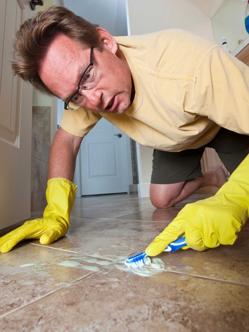 A man scrubbing the floor tiles