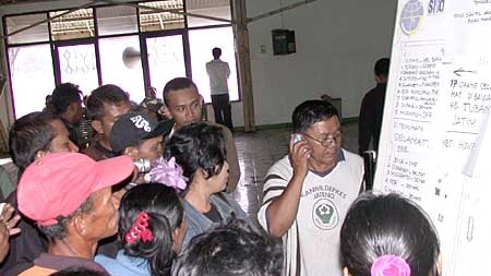 Relatives check for the names of survivors of the ferry sinking at a port in Central Java.