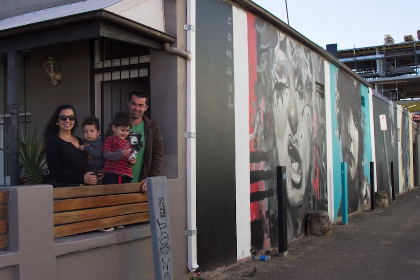 Brett Gough, Flavia Deoliveira and their two children outside their home in Marrickville