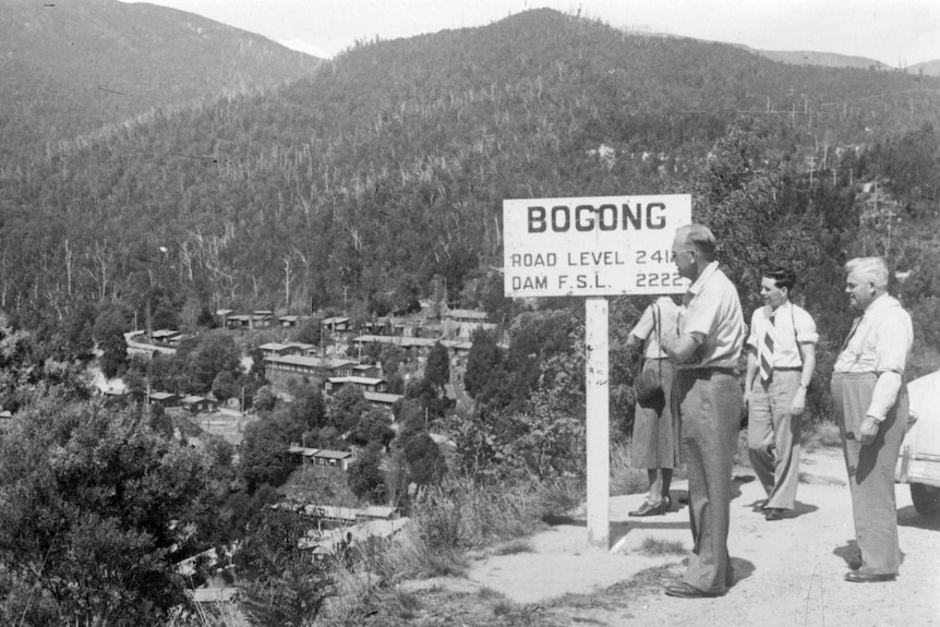 A black and white photo from the past of men looking at Bogong Village 