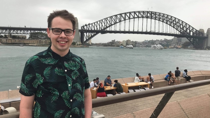 QUT student Liam Clarkson poses in front of Sydney Harbour Bridge
