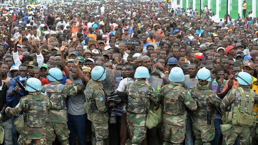 UN peacekeepers try and control Haitians queueing for aid
