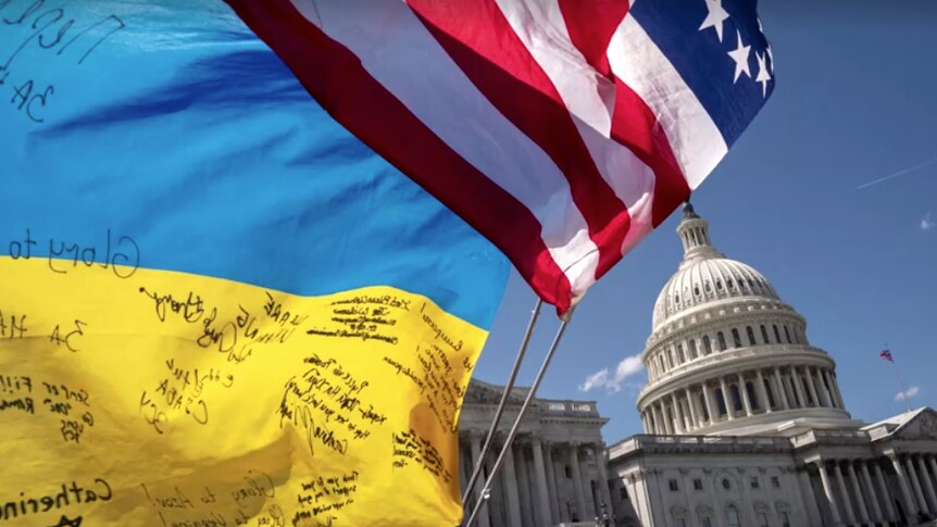 A ukraine flag and us flag in front of the capitol building. 